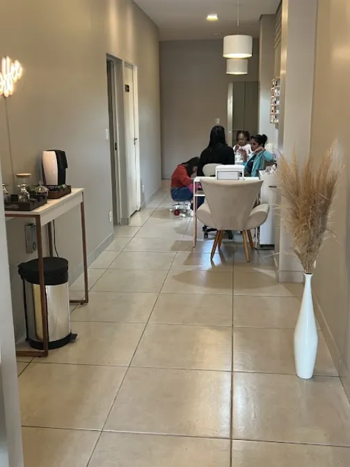 Corredor com o cantinho do café e, ao fundo, a bancada da esmalteria