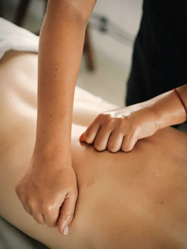 Mãos de terapeuta fazendo massagem modeladora nas costas de uma cliente